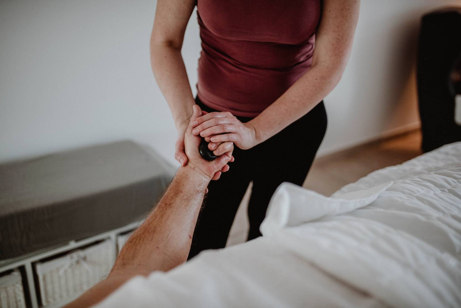 Professional therapist performing a volcanic hot stone massage in Spirit massage salon, Maribor.